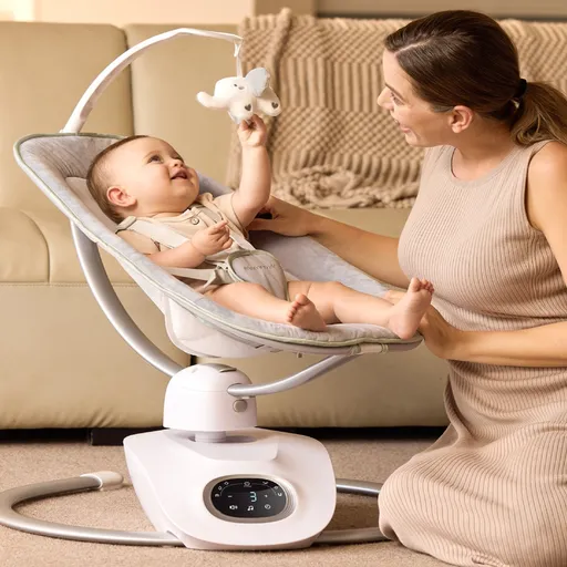 Eine Mutter, die vor einer Babywiege mit Baby kniet.