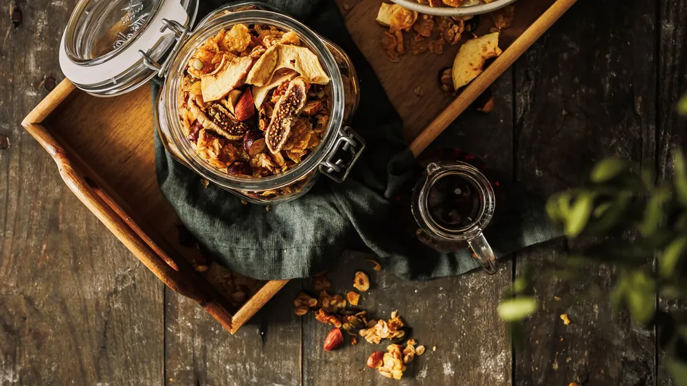 Ein Glas voll Granola auf einem Holz-Hintergrund