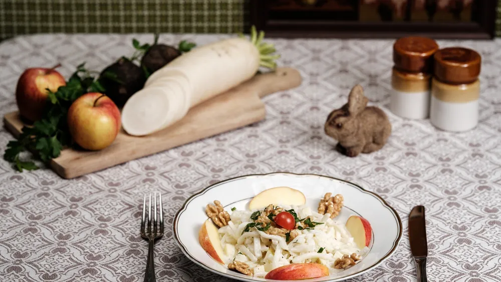 Rettichsalat mit Apfel angerichtet an einem nostalgisch gedeckten Tisch mit Spitzentischdecke