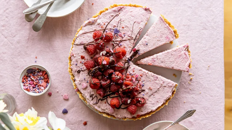 Himbeer-Tarte mit frischen Himbeeren und Creme auf rosa Hintergrund