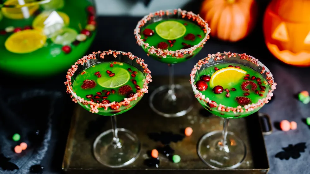 Grüner Halloween Cocktail mit Granatapfelkernen in Champagnergläsern