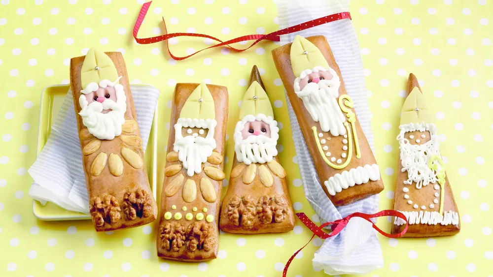 Lebkuchen-Nikoläuse auf gelbem Hintergrund mit Marzipandekor