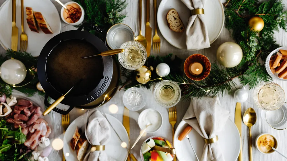 Ein Tisch, gedeckt ür Suppen-Fondue mit vielen kleinen Schälchen und einem Fonduetopf