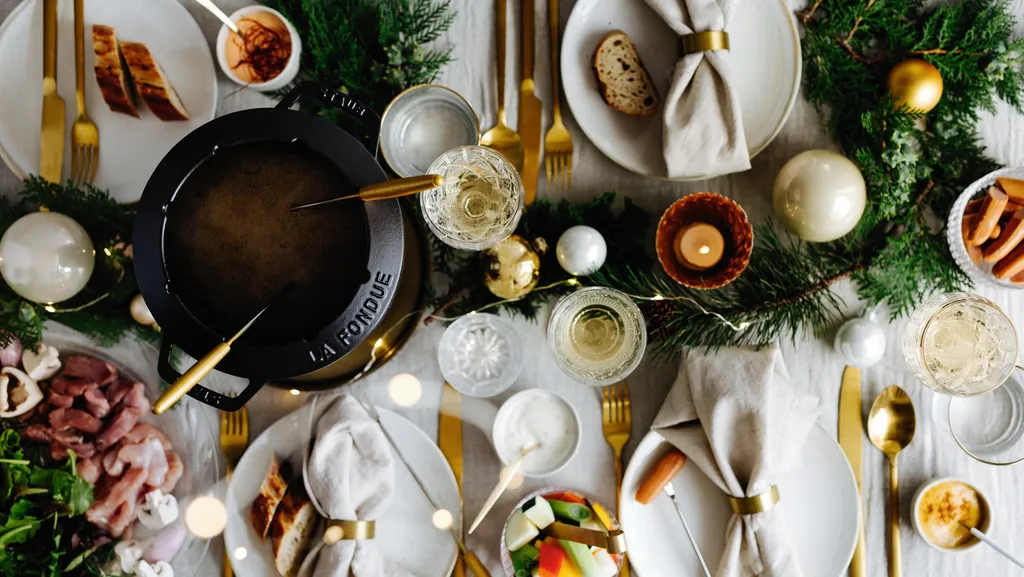 Ein Tisch, gedeckt ür Suppen-Fondue mit vielen kleinen Schälchen und einem Fonduetopf