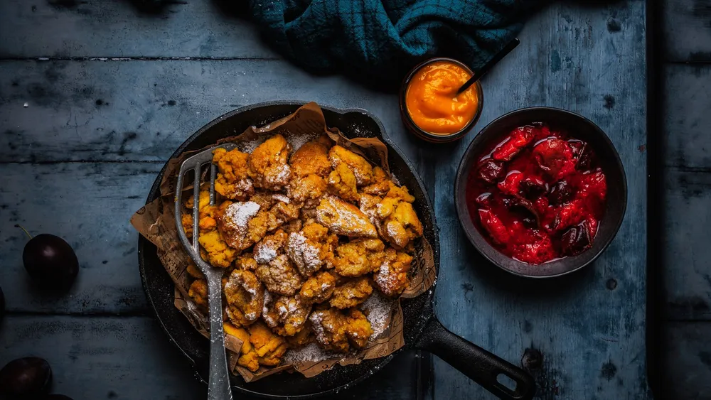 Kürbis-Kaiserschmarren mit Zwetschkenröster auf blaugrauem, dunklen Hintergrund
