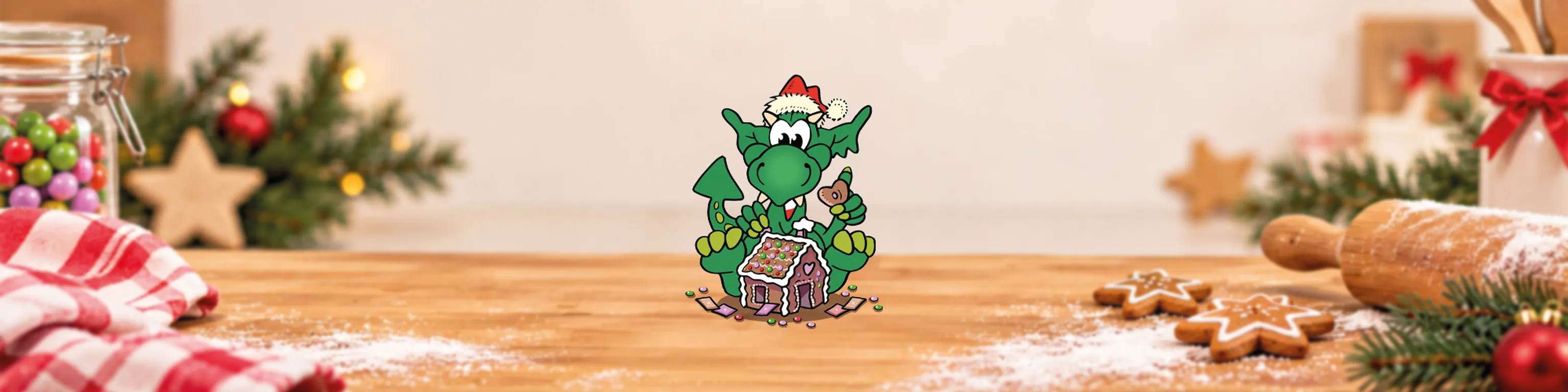 Der kleine grüne Drache INGO beim Bauen eines Lebkuchenhauses
