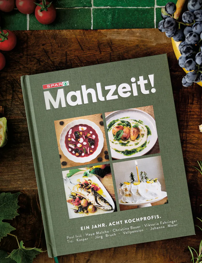 Vorschau des SPAR-Mahlzeit-Kochbuchs auf einem hölzernen Brett
