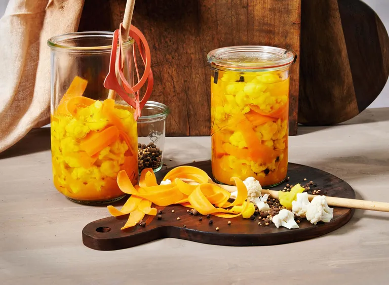 Selbst eingelegte orientalische Karfiol-Pickles mit Karotten und Gewürzen in Einmachgläsern