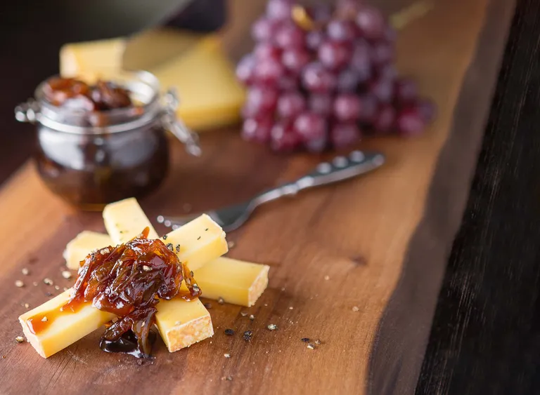 Karamellisierte Zwiebelmarmelade im Glas als Begleiter zu Camembert auf frischem Brot