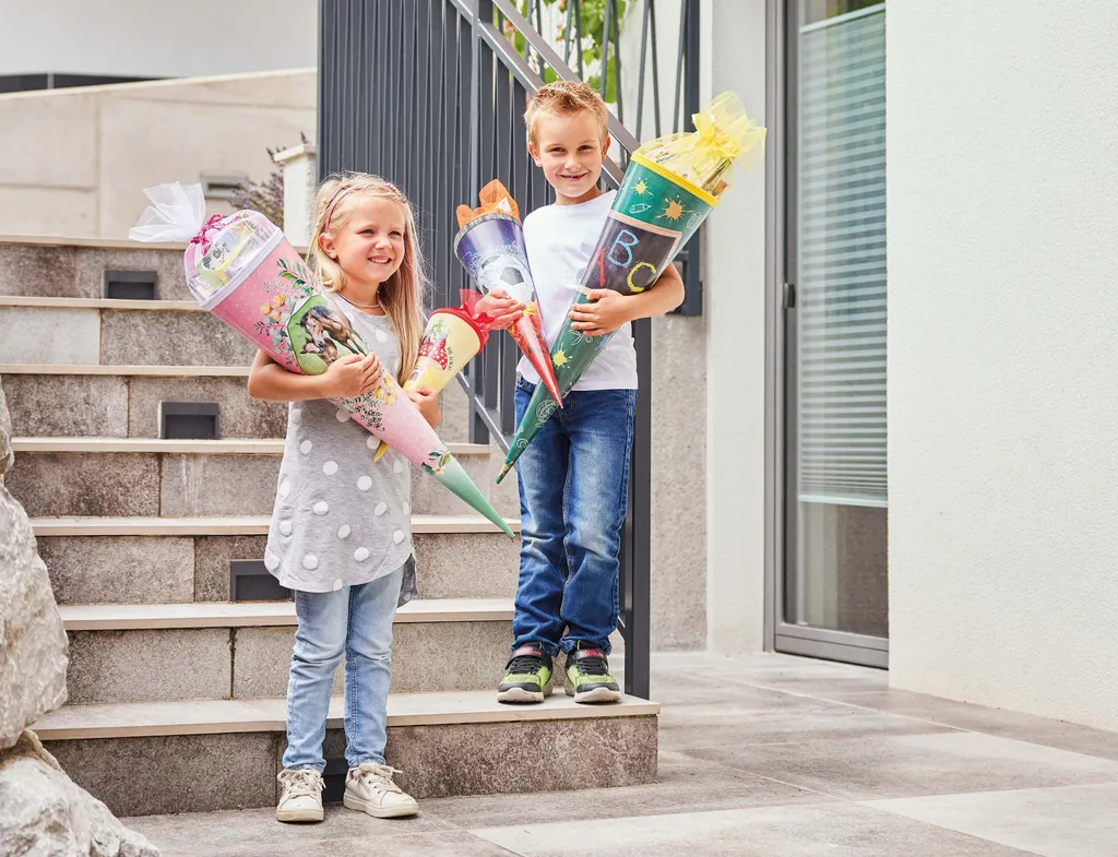 Zwei Kinder präsentieren ihre gefüllten INTERSPAR Schultüten