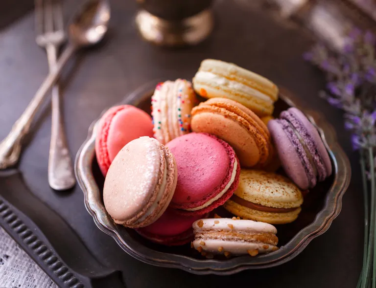 Ein Teller voller frisch gebackener, bunter Macarons
