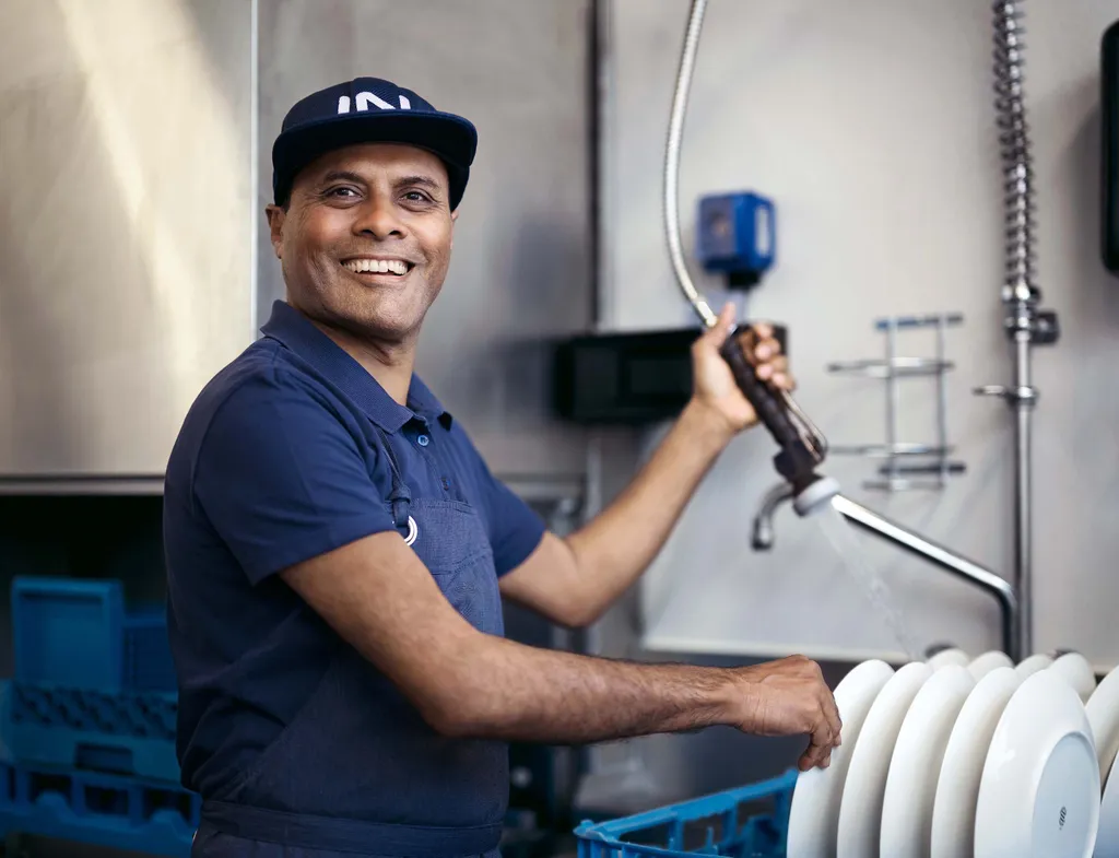 Mitarbeiter von INTERSPAR beim Abwaschen von Geschirr in der Gastronomie