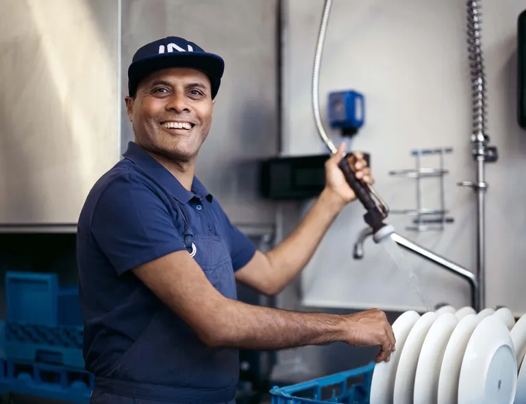 Mitarbeiter von INTERSPAR beim Abwaschen von Geschirr in der Gastronomie