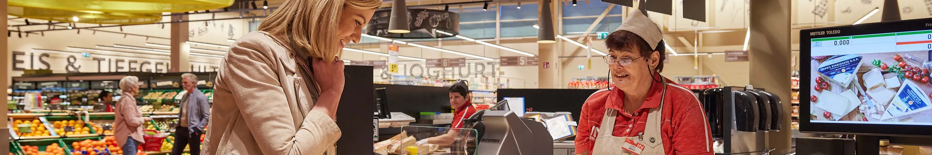 INTERSPAR-Mitarbeiterin berät eine Kundin an der Feinkosttheke im Markt
