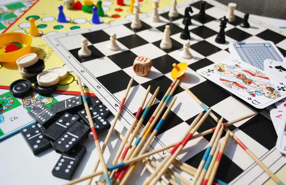 Verschiedene Brettspiele mit Schach, Domino, Mikado, Karten und Spielfiguren auf einem Tisch
