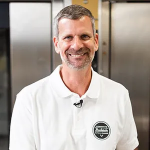 Handwerksbäcker Martin Pürrer der INTERSPAR-Bäckerei lächelt mit seinem Bäckerliebling in die Kamera
