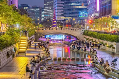 Abendstimmung am Cheonggyecheon-Bach im Zentrum von Seoul mit beleuchteter Skyline
