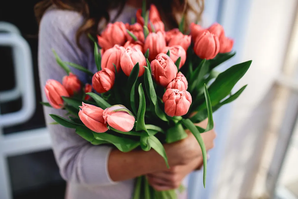 Eine Frau hält einen Tulpenstrauß in beiden Händen