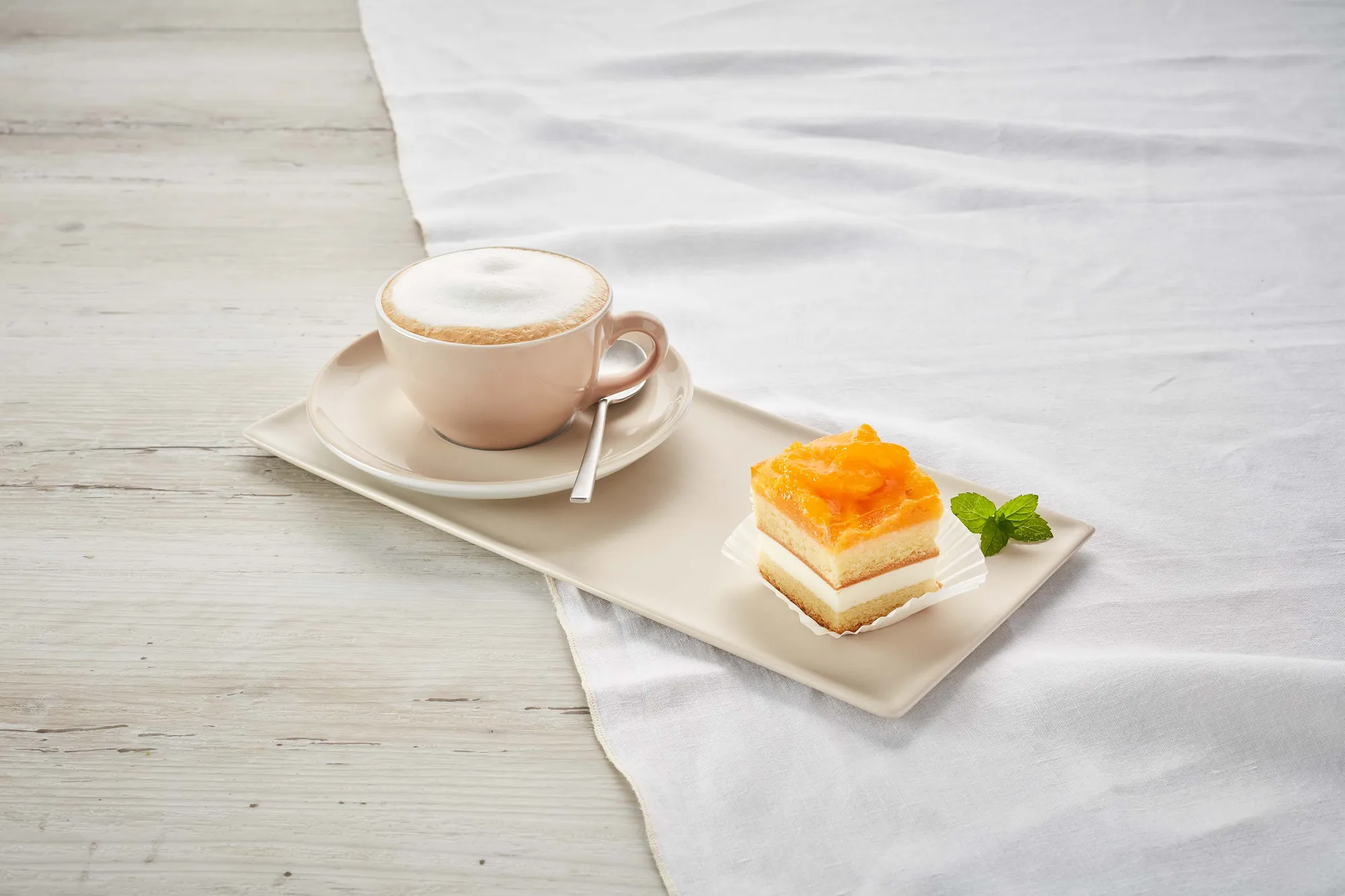 Eine Mandarinenschnitte mit einem Cappuccino aus dem INTERSPAR-Restaurant