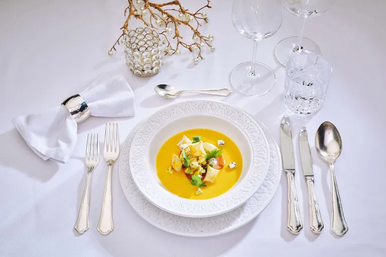 Cremige indische Kürbissuppe mit Croûtons, Kräutern und Gewürzen