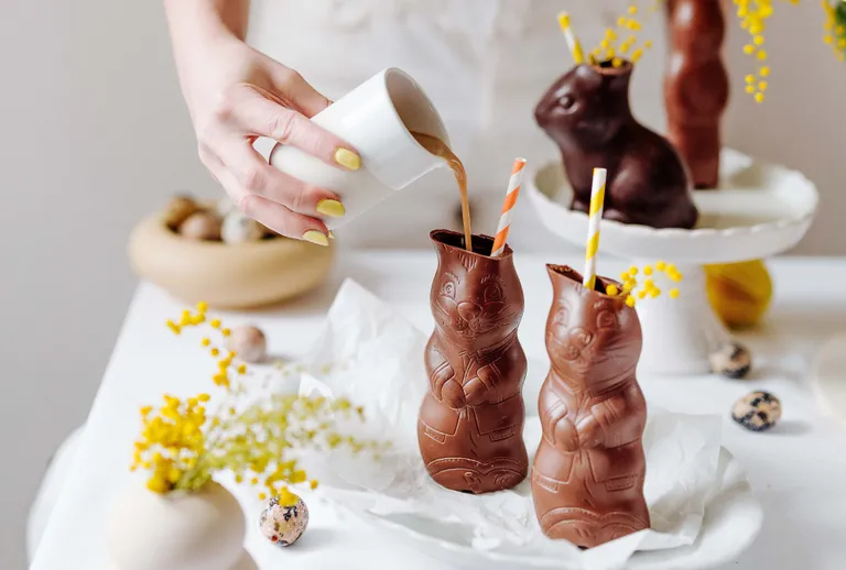 Schokoladen-Osterhasen werden mit heißer Milch zu einem Schokoladengetränk gefüllt