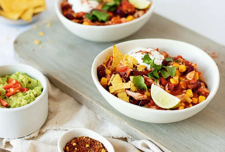 Würziges Jackfruit-Chili mit Avocado, Radieschen, Limette und Tortilla-Chips