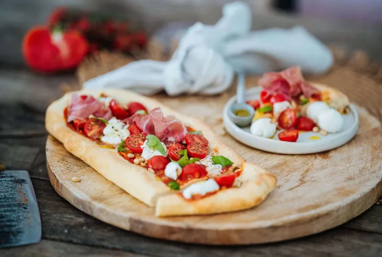 Knusprige Pinsa Romana mit Prosciutto, Burrata, Cherrytomaten und Basilikum