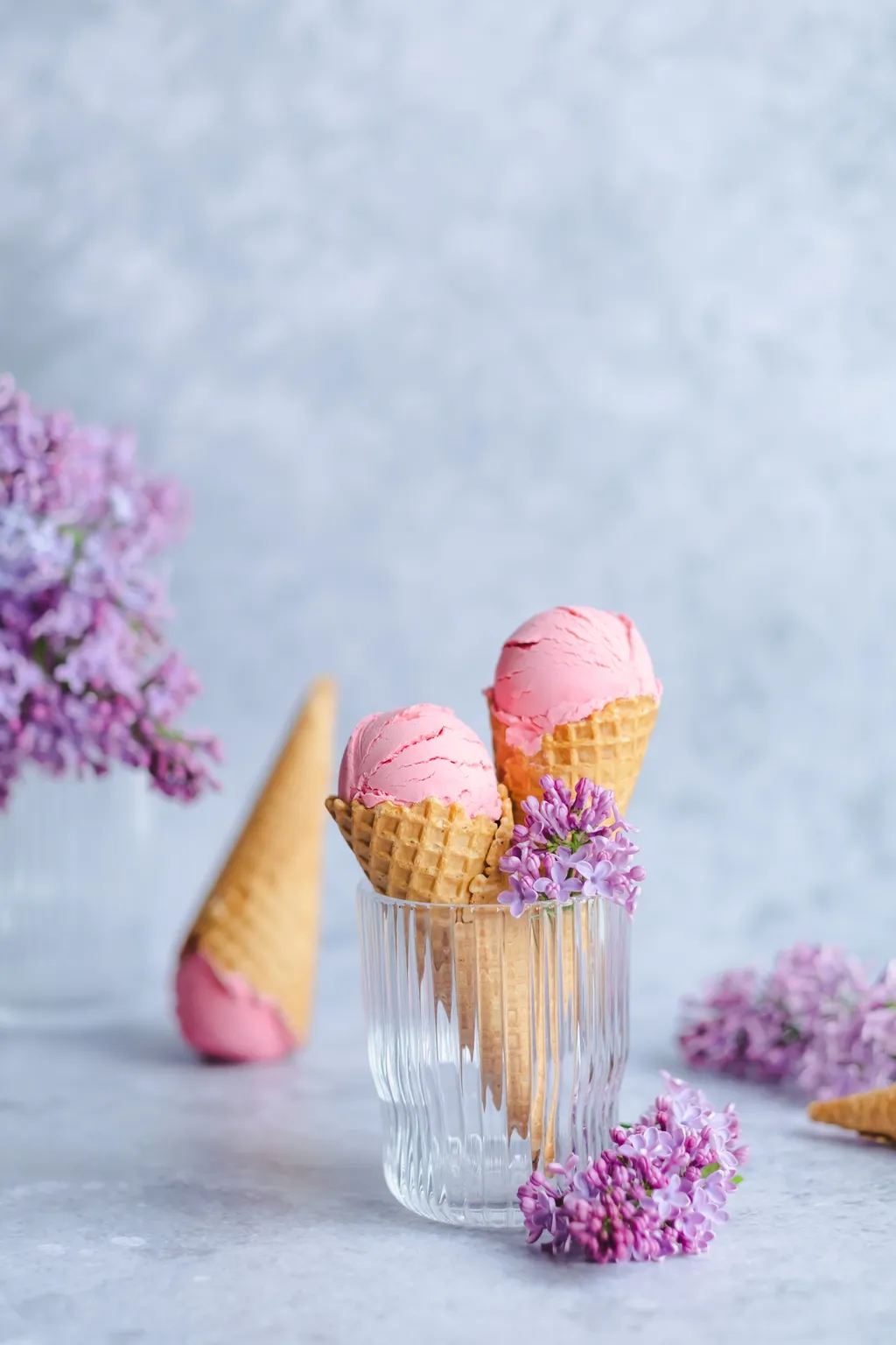 Erdbeereis in zwei Tüten mit lila Blüten in einem Glasgefäß