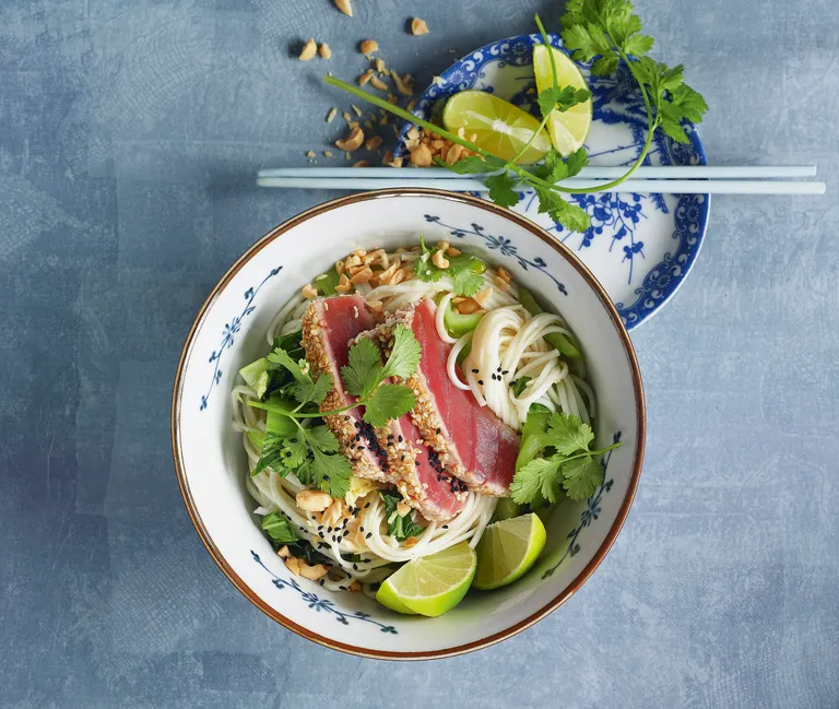 Ein großer Suppenteller gefüllt mit mariniertem Wasabi-Sesam-Thunfisch und Nudeln in einer Brühe
