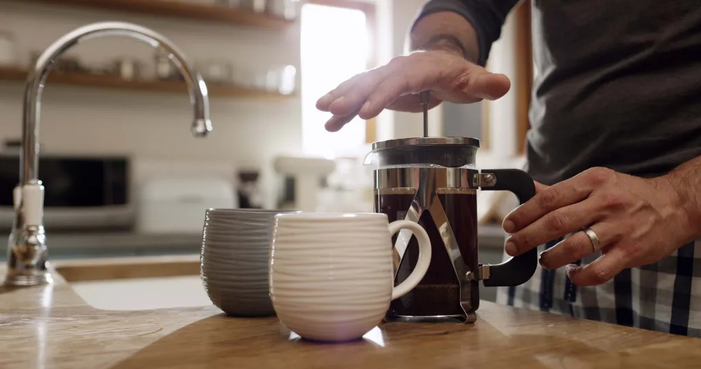 Kaffee wird in einer French Press durch Herunterdrücken des Stempels zubereitet