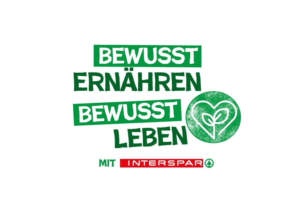 Grüner Text auf einem weißen Kreis mit der Aufschrift „Bewusst ernähren, bewusst leben“, einem Pflanzenherz-Symbol und dem Schriftzug „Mit INTERSPAR“ darunter.