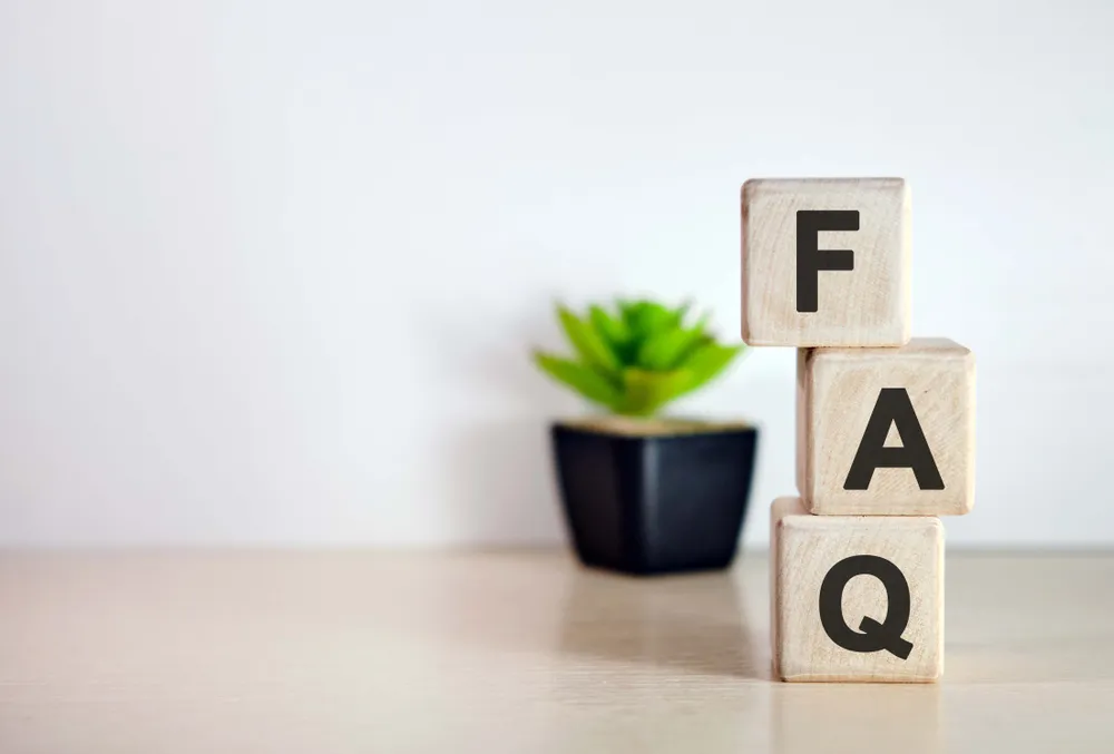 Holzwürfel mit den Buchstaben FAQ als Symbol für häufige Fragen und Antworten
