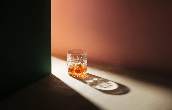 Ein Glas Whisk(e)y steht am Boden.