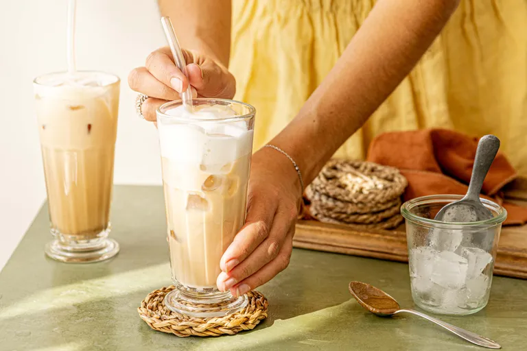 Cremiger Tahini Iced Latte mit Eiswürfeln im Glas, frisch zubereitet