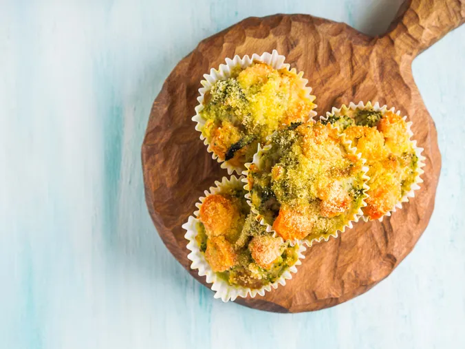 Herzhafte Brokkoli-Muffins mit Käse auf einem Holzbrett als gesunde Schuljause