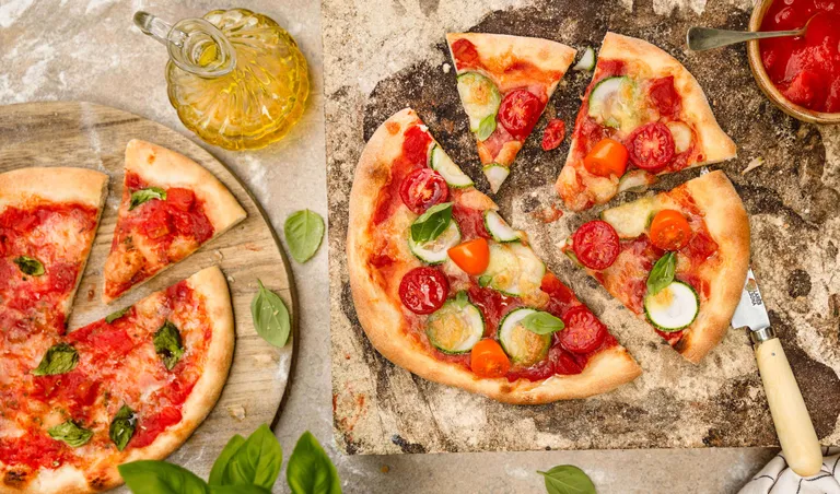 Klassische italienische Pizza mit Tomaten, Zucchini, Cherrytomaten und Basilikum