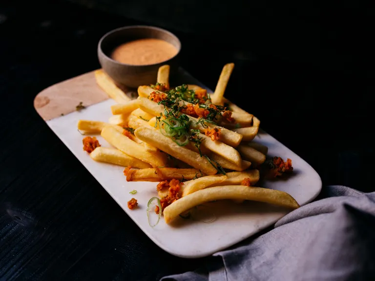 Knusprige Pommes frites mit knusprigem Topping, Frühlingszwiebeln und cremiger Kimchi-Mayo