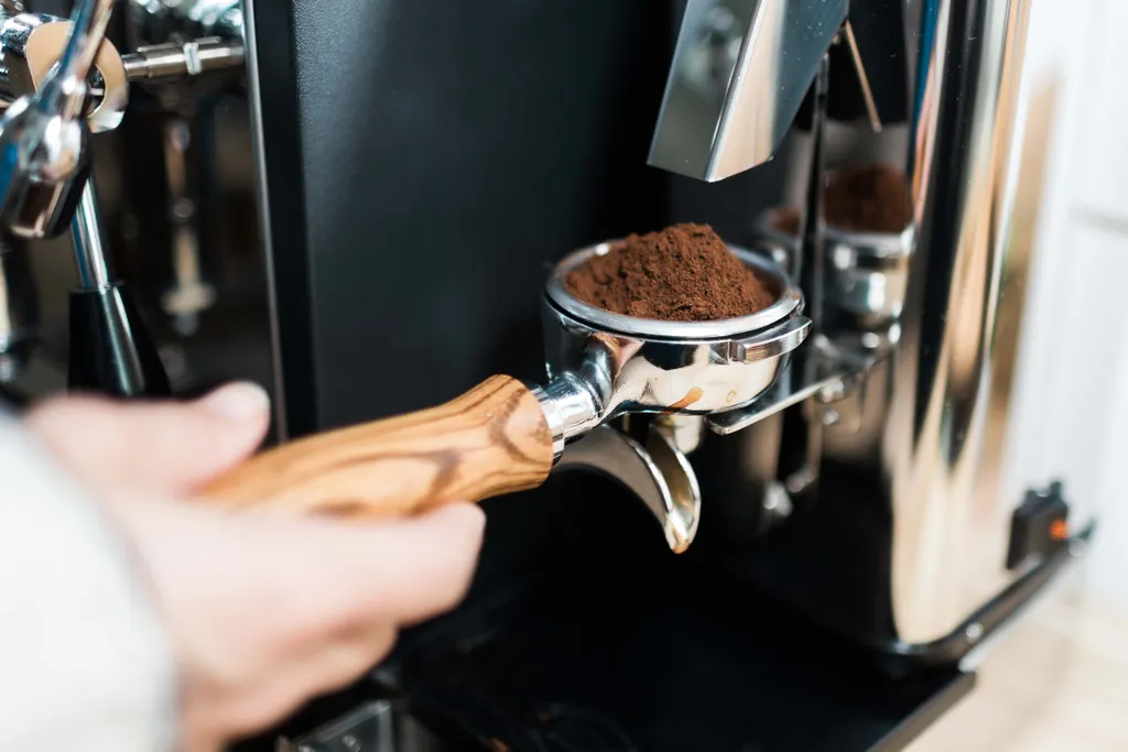 Frisch gemahlener Kaffee wird direkt in den Siebträger einer Kaffeemaschine gefüllt