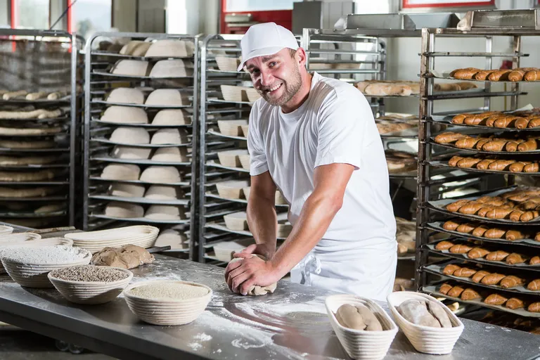Bäckermeister Sascha Prehofer der INTERSPAR-Bäckerei lächelt mit seinem Bäckerliebling in die Kamera