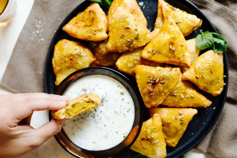 Knusprige indische Samosas mit würzigem Joghurt-Dip
