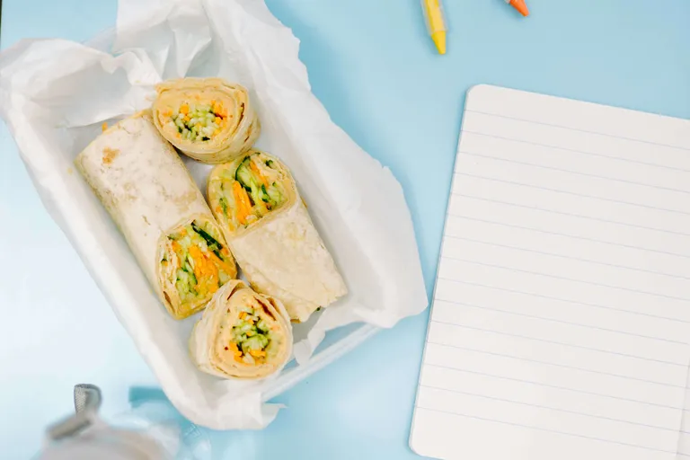 Wraps mit frischem Gemüse und Aufstrich in einer Brotdose als gesunde Schuljause
