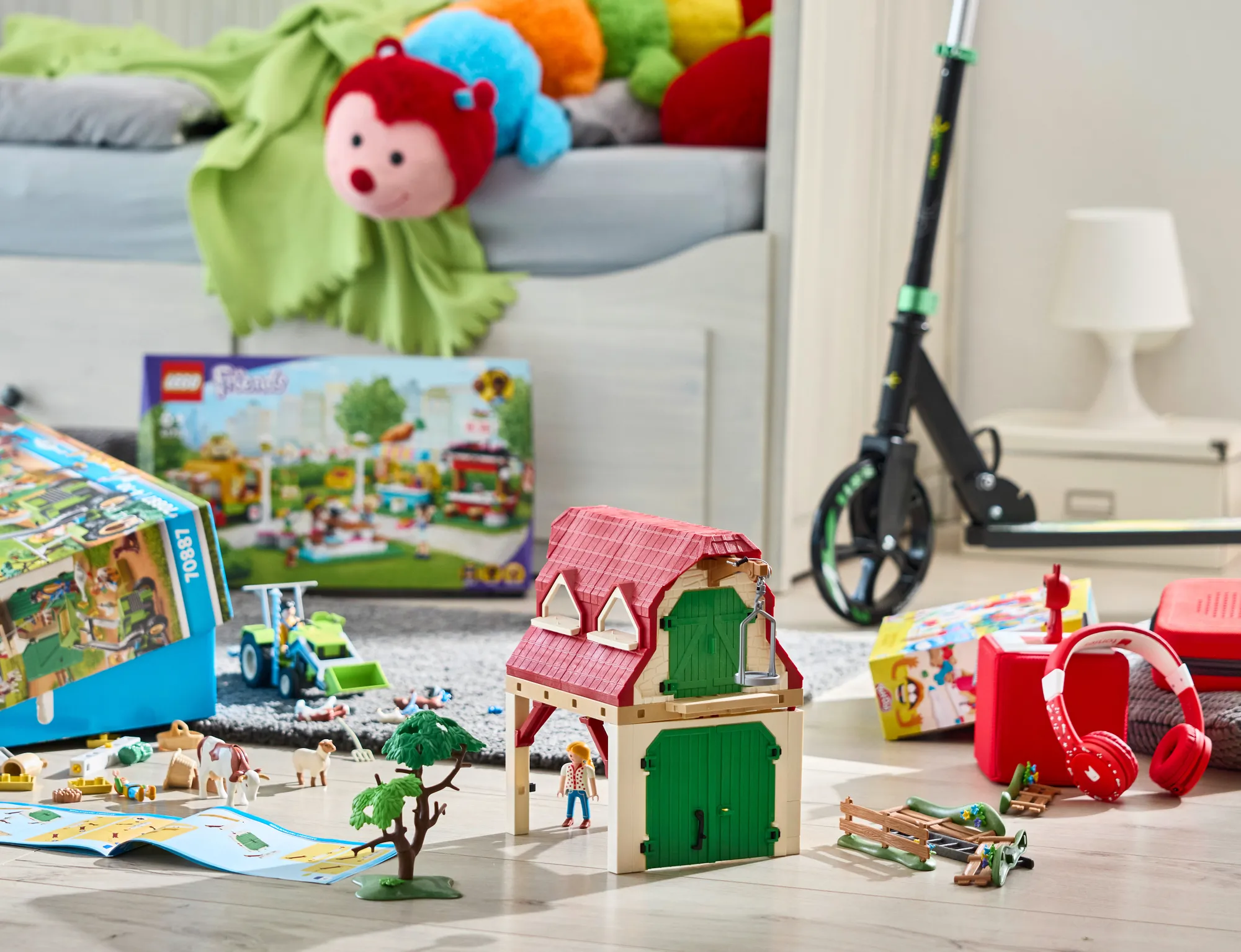 Mehrere verschiedene Spielsachen, von Playmobil über Tonies bis hin zu einem Roller und Stofftieren