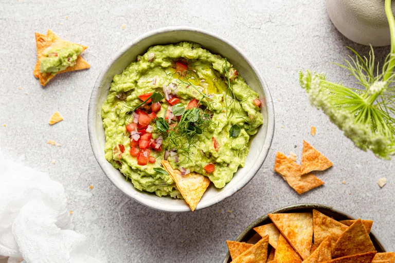Cremige Guacamole mit Tomaten, Zwiebeln und knusprigen Tortilla-Chips