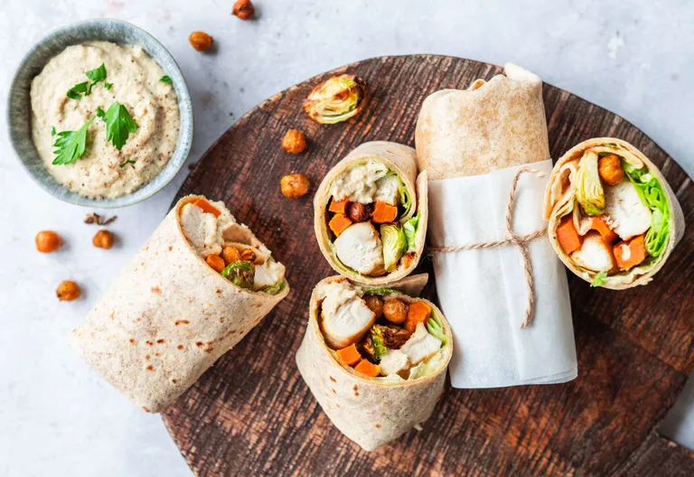 Vollkorn-Wraps mit Hähnchen, Gemüse und Hummus als gesunde Meal-Prep-Mahlzeit
