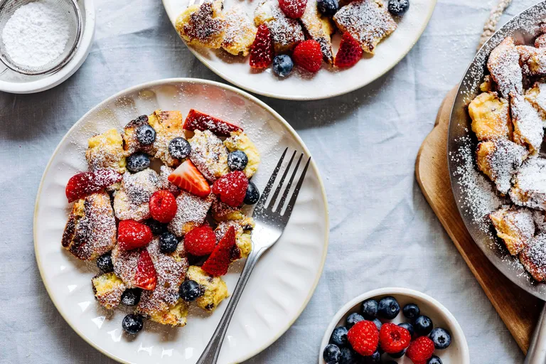 Frischer Kaiserschmarrn mit Puderzucker, Erdbeeren, Himbeeren und Heidelbeeren