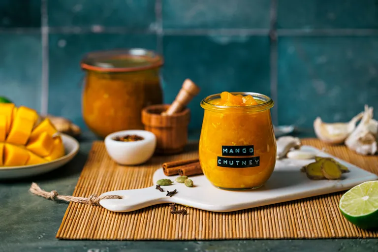 Glas mit würzigem Mango-Chutney und frischen Zutaten