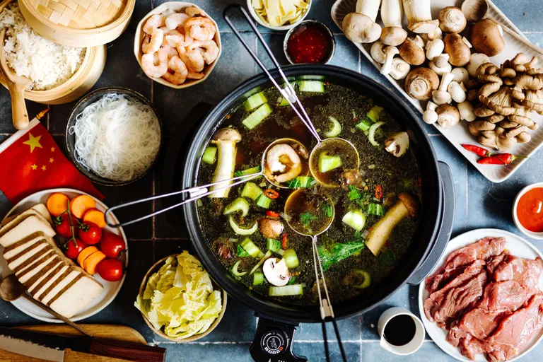 Chinesischer Hot Pot mit Pilzen, Garnelen, Gemüse, Glasnudeln und Fleisch