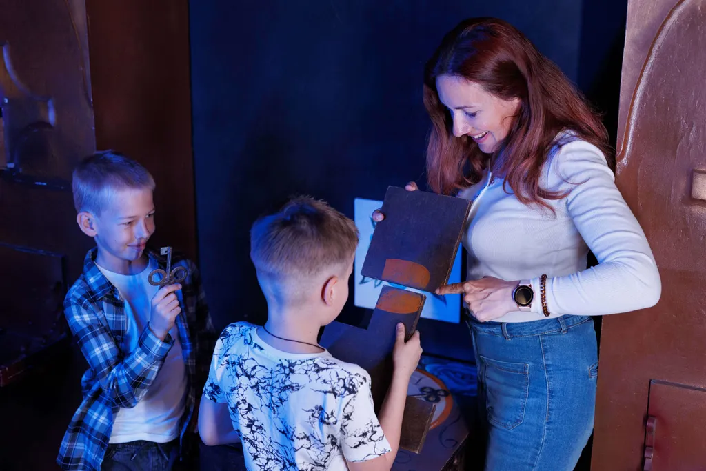 Erwachsene und Kinder lösen gemeinsam eine Aufgabe in einem Escape Room