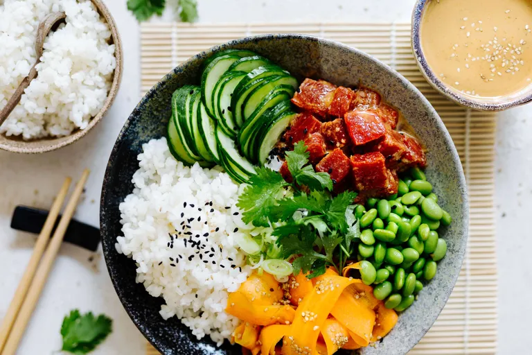 Bunte Veggie Bowl mit Reis, Edamame, Gurken, mariniertem Tofu und Karotten
