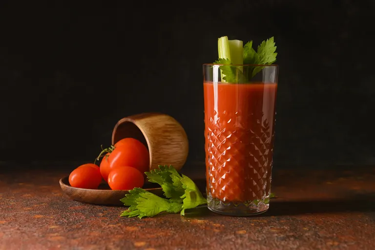 Bloody Mary im Longdrinkglas mit Sellerie, frischen Tomaten und Sellerieblättern